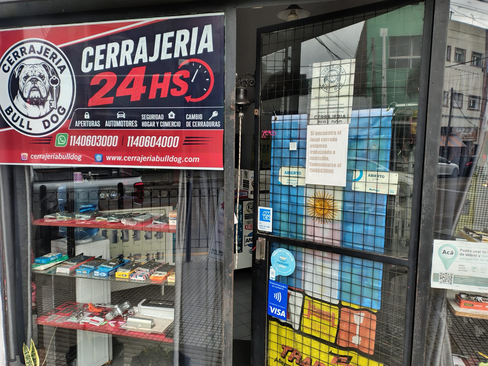 Fachada frontal de Cerrajería Bulldog con cartel 24HS y logo