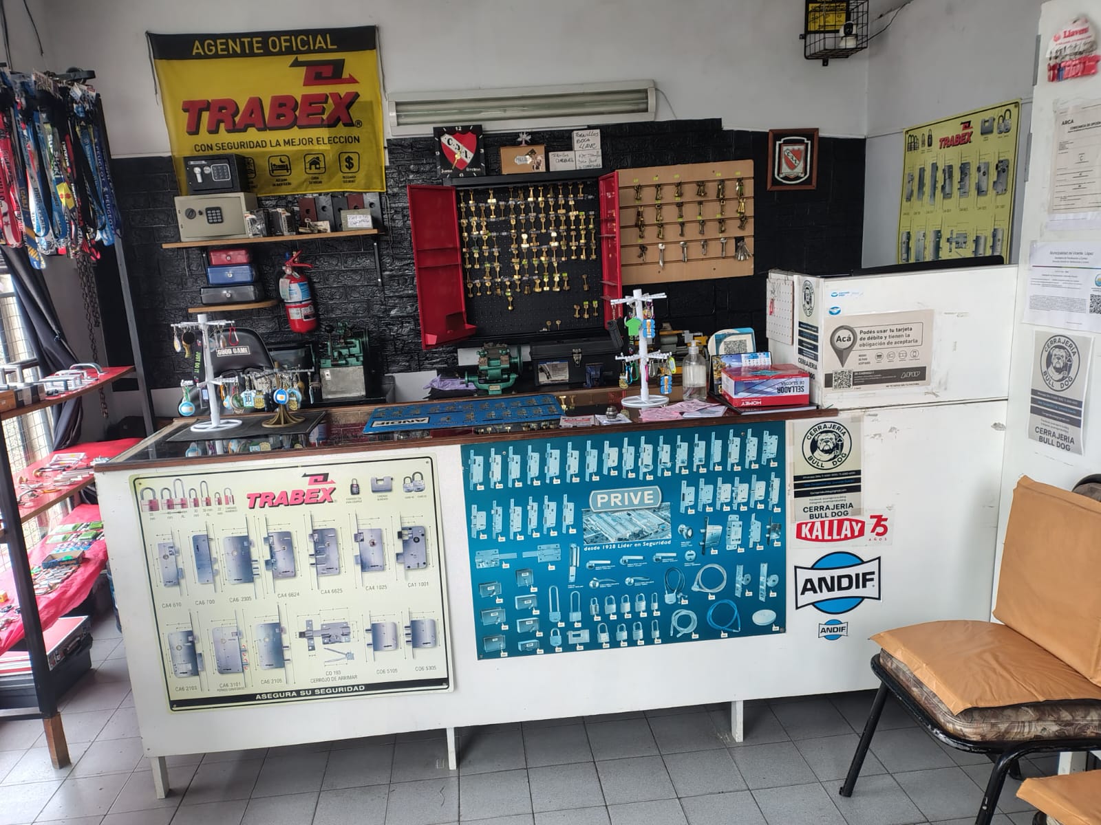 Interior del taller de Cerrajería Bulldog — mostrador con productos TRABEX, PRIVE, KALLAY y herramientas profesionales